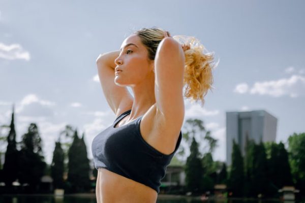 Fit woman in a black tank top enjoys a sunny workout outdoors in Ciudad de México, embracing wellness and healthy living.